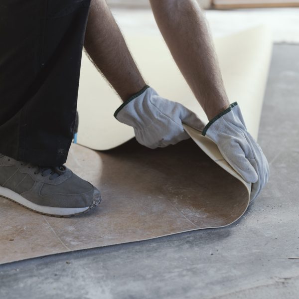 Professional contractor removing an old linoleum flooring: home renovation concept